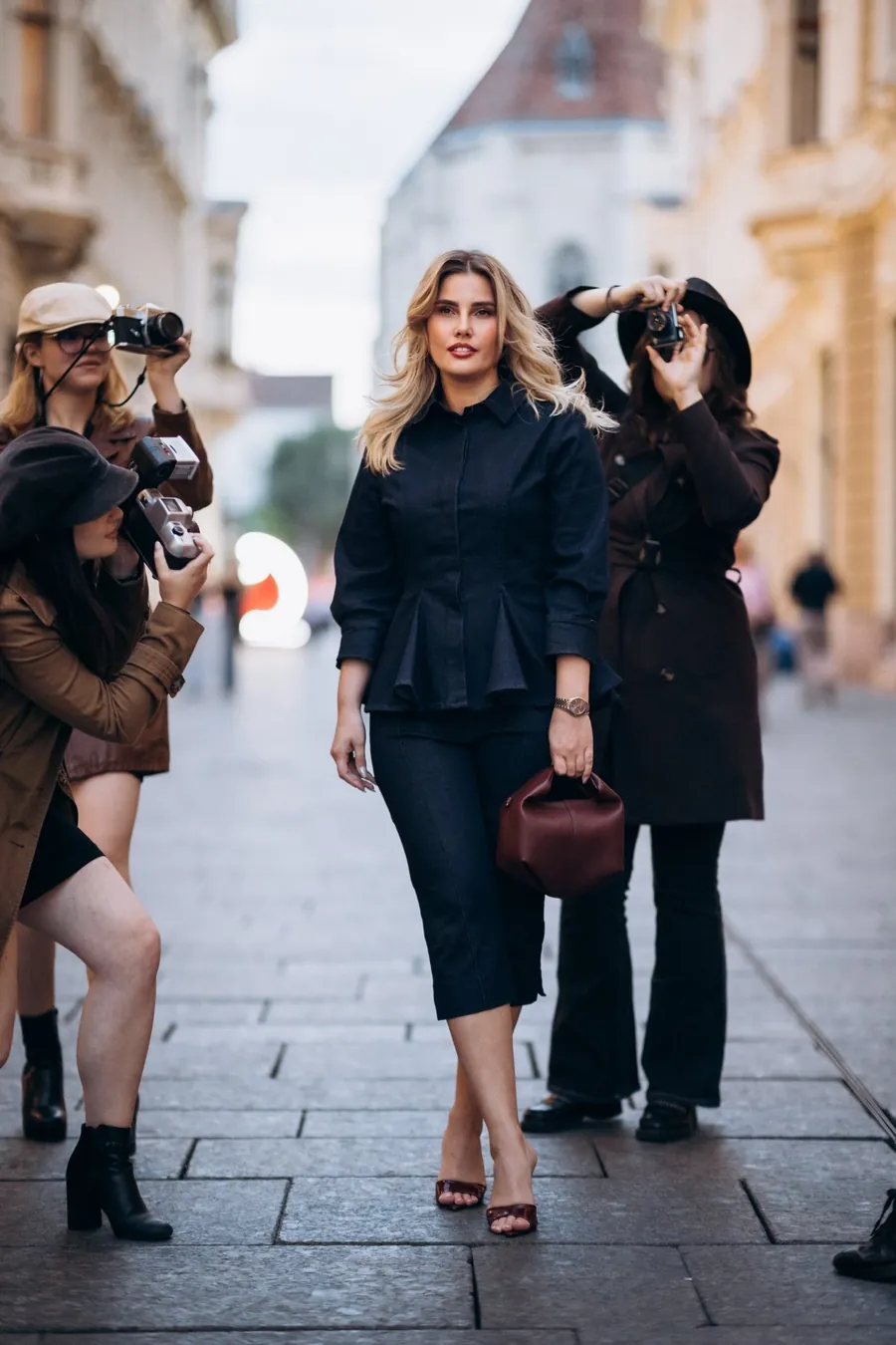 Gianina Matei pe o stradă din centrul Clujului, fotografiată de trei fotografi