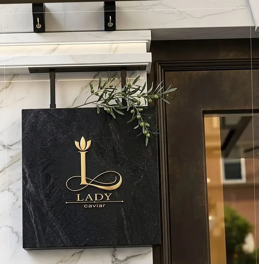 Firmă Lady Caviar din piatră neagră pe fațadă de marmură